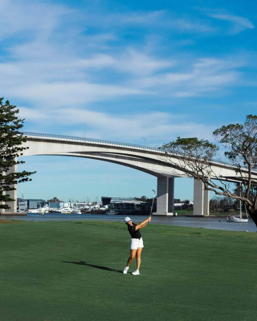 A Woman Playing Golf near the Gateway Bridge over Brisbane River