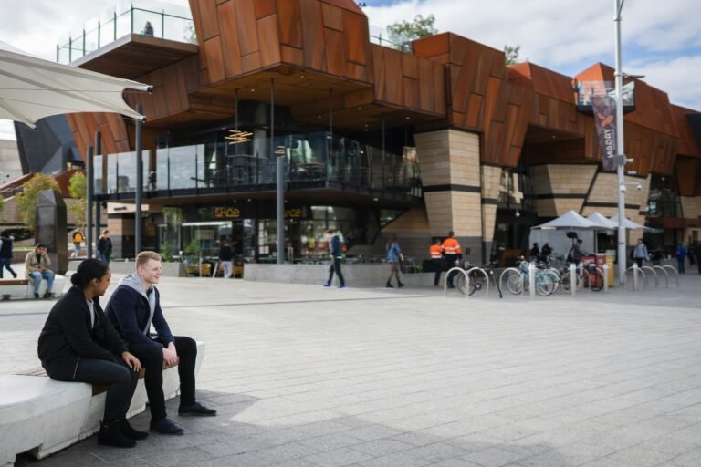 Friends sitting together in the heart of Perth at Yagan Square and planning to travel perth